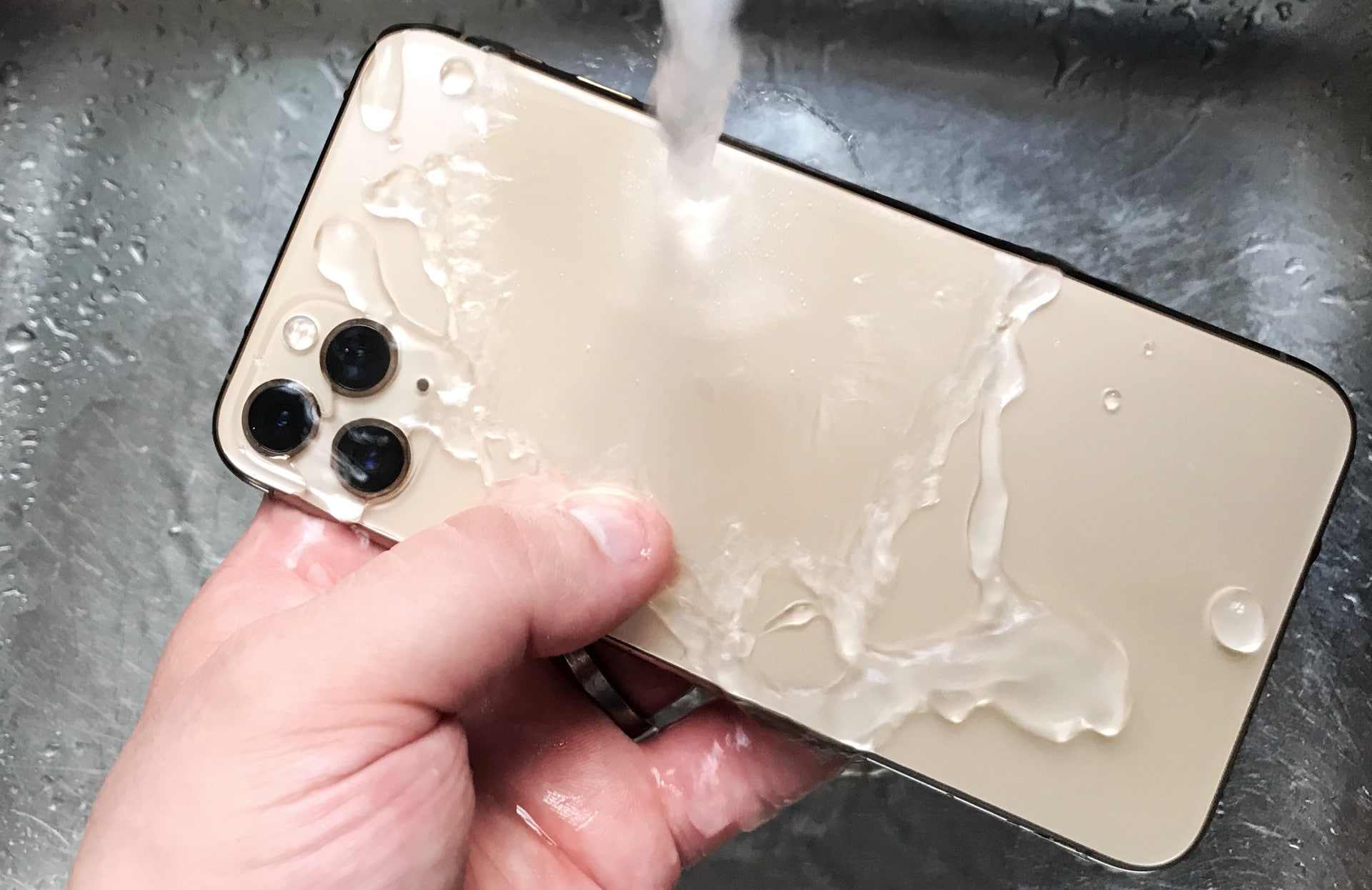 Washing an iPhone 11 Pro Max under a tap
