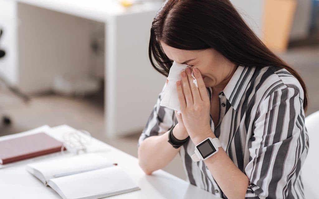 Covering a nose with a tissue during a sneeze