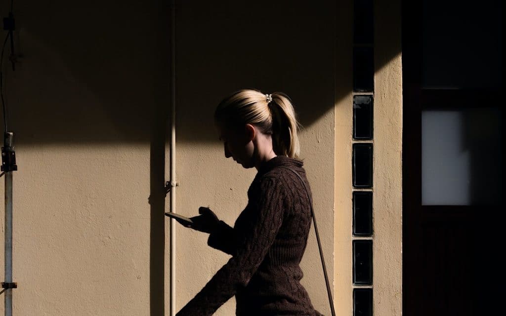 Photo of a woman walking by using their phone