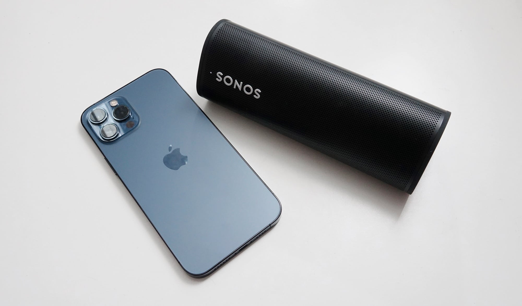 The Sonos Roam next to an iPhone 12 Pro Max.