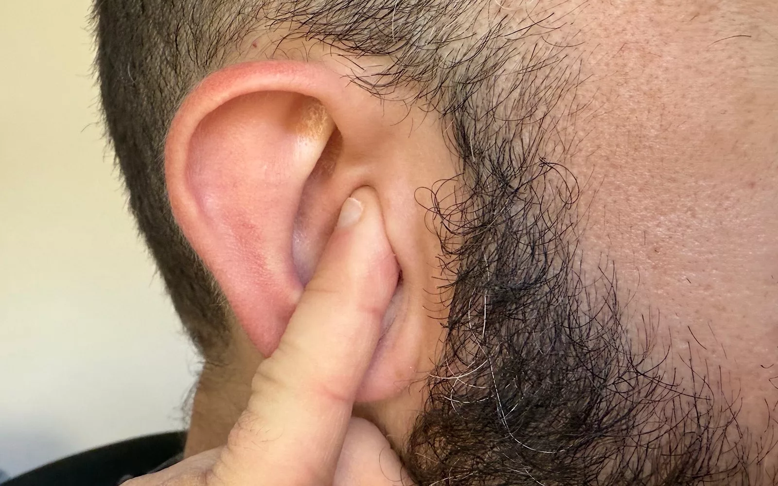 Sticking your pinky finger's soft part in your ear is roughly how much of your ear an earphone tip out will use.